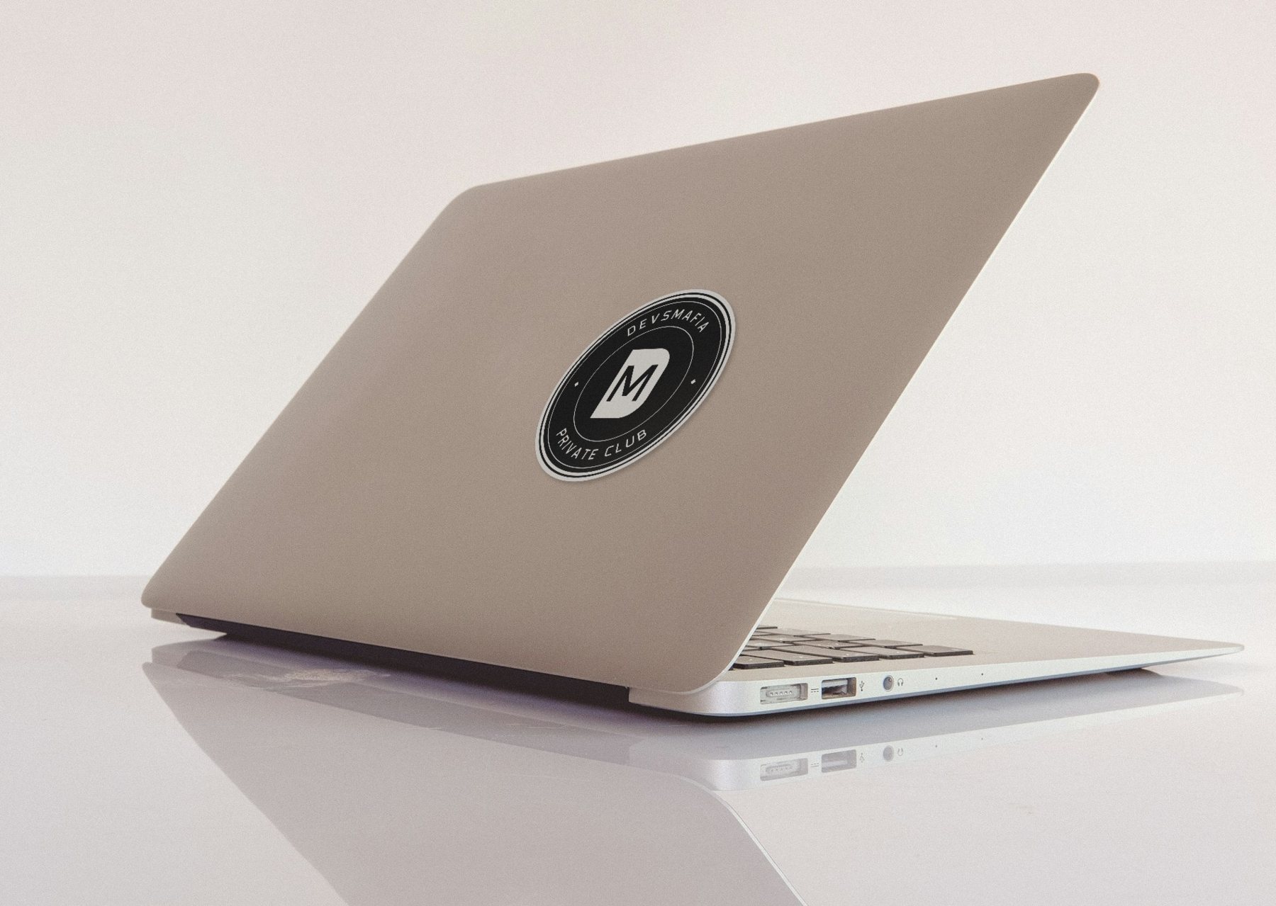 Adesivo do brasão DEVSMAFIA colado em um notebook