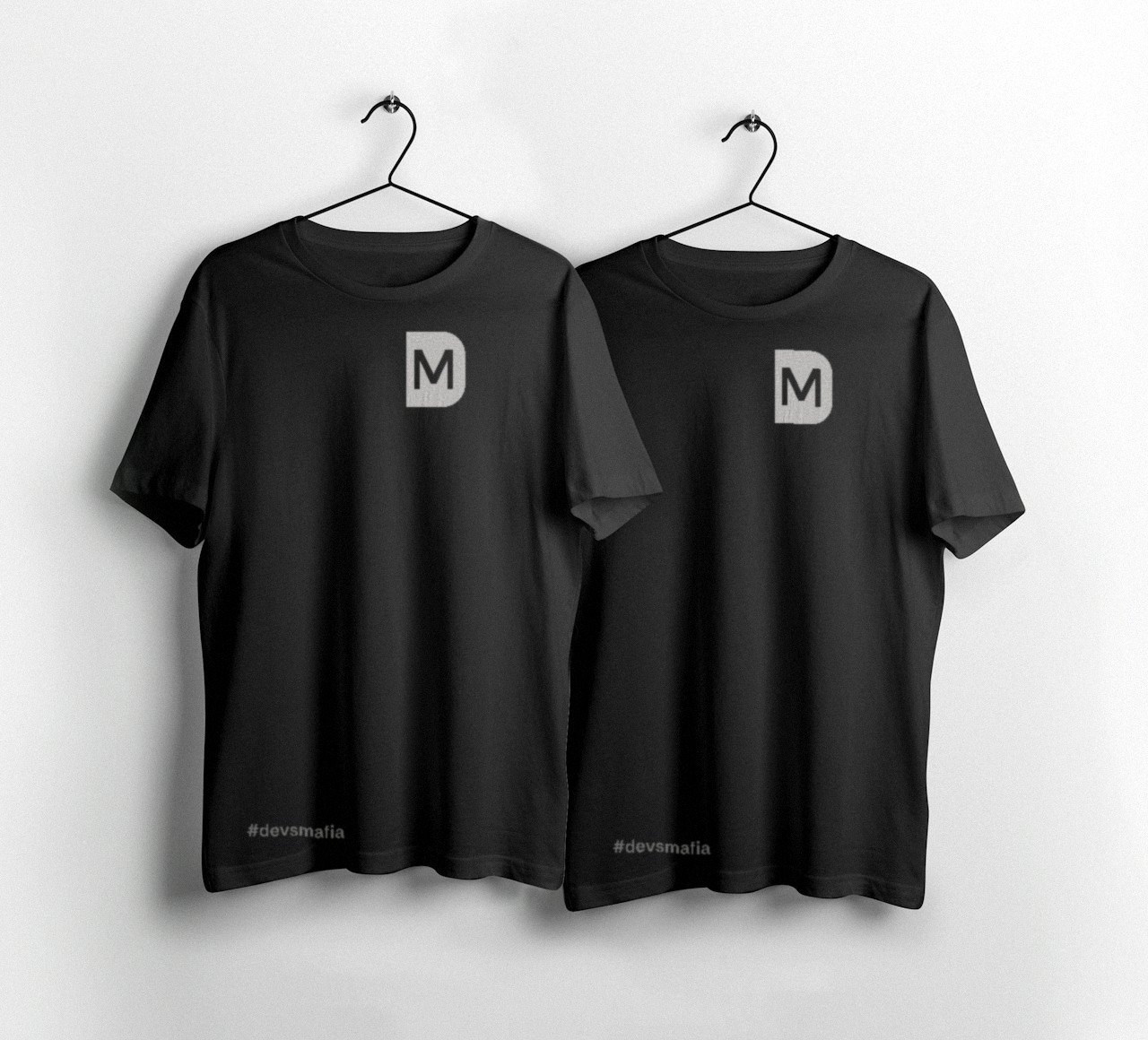 Camisetas pretas DEVSMAFIA com o monograma no peito